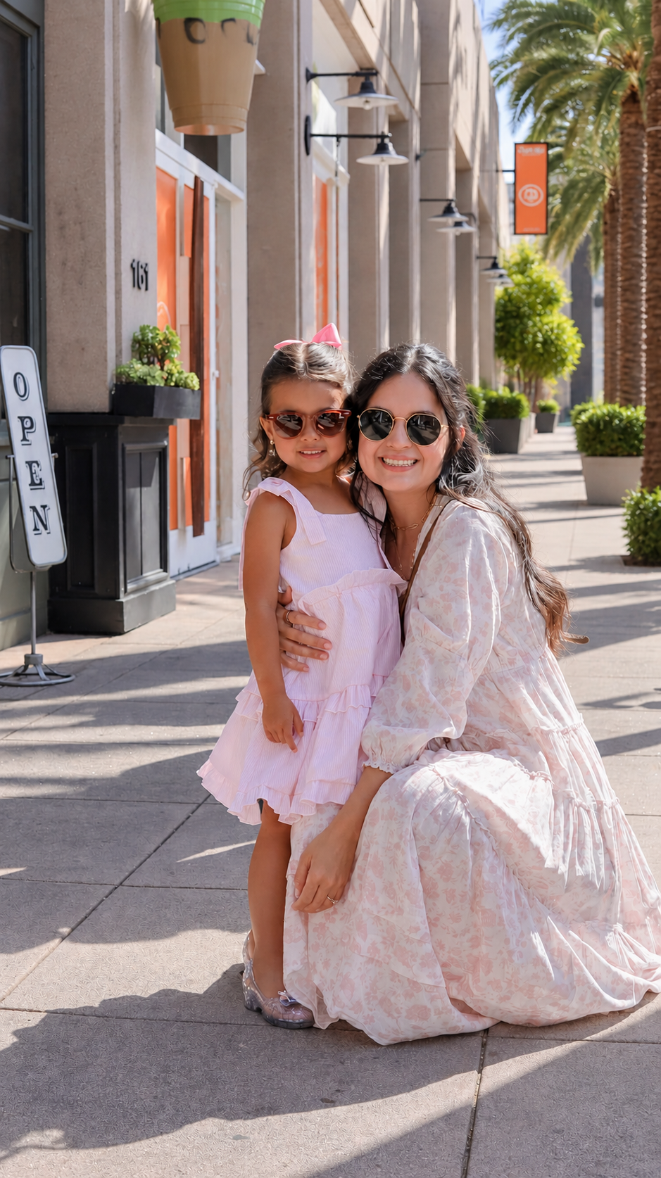 Cindy Bernal hugging her young daughter on a sunny sidewalk