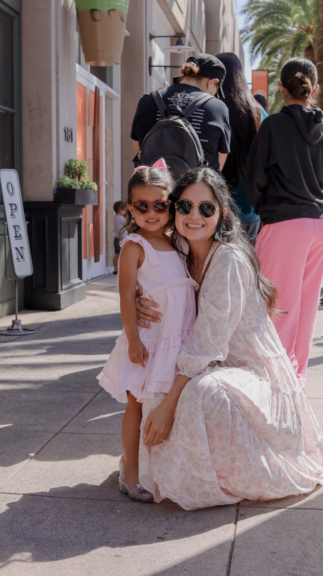Cindy Bernal hugging her young daughter on a sunny sidewalk